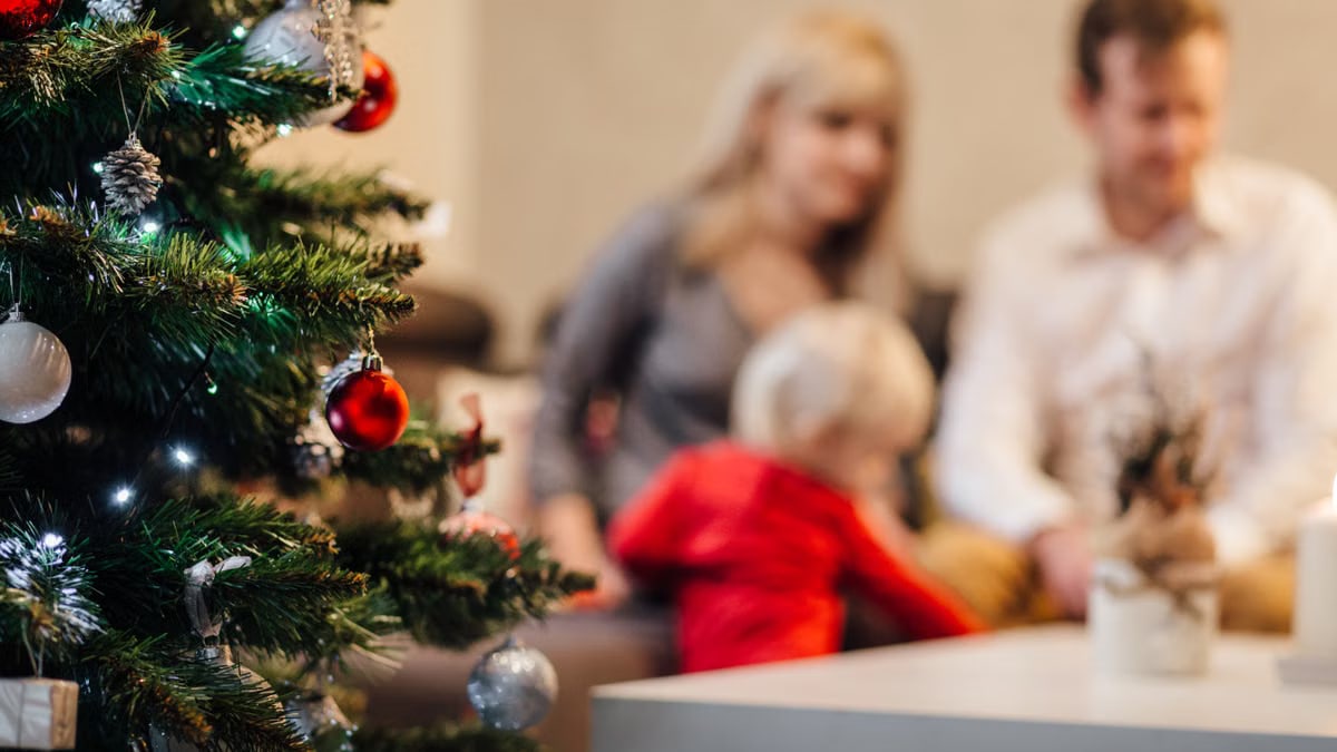 A cozy family gathering by the Christmas tree, enjoying festive decorations.